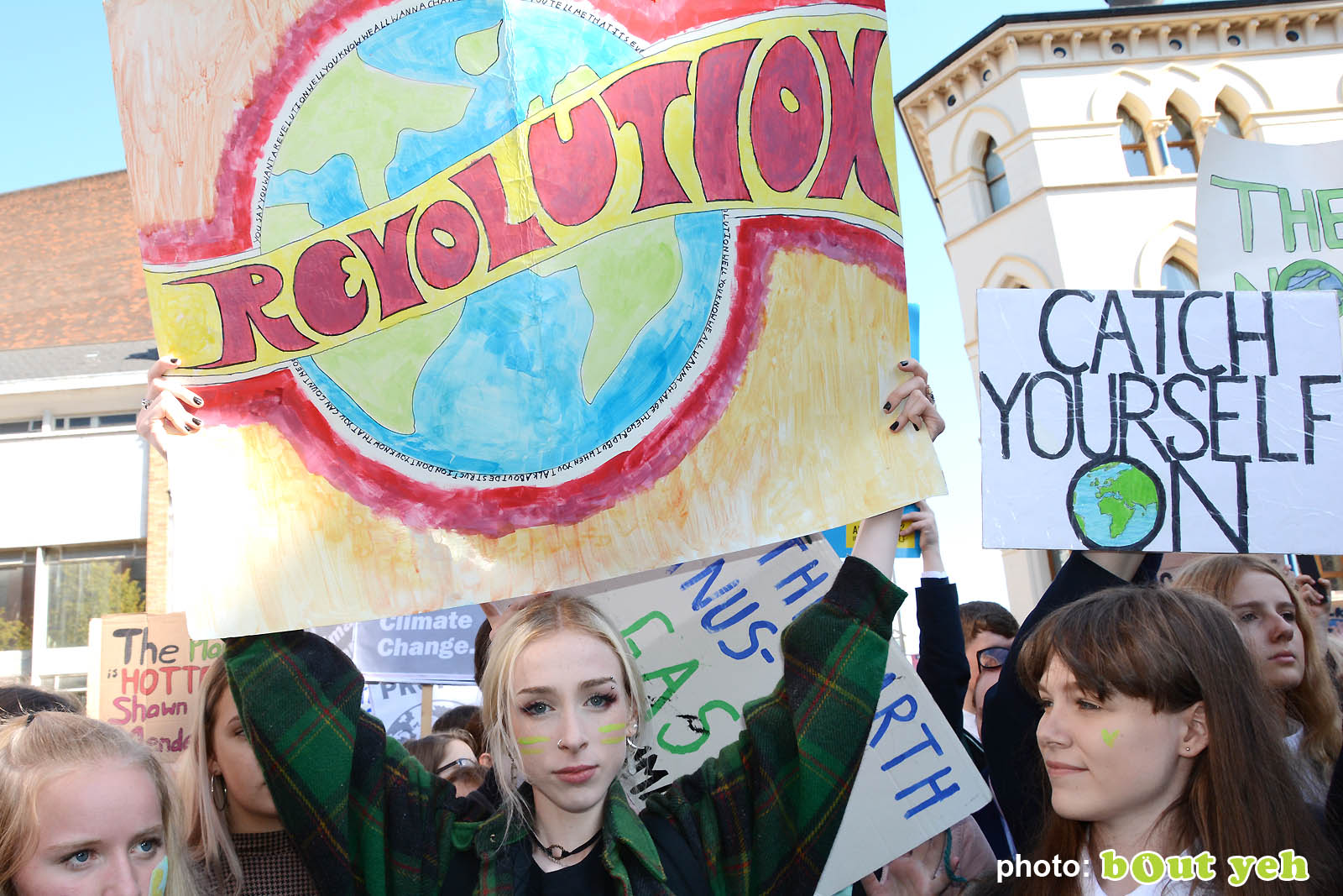Young woman holding banner above her head at the strike for climate protest in Belfast. Photo 8949 by Bout Yeh photographers Belfast